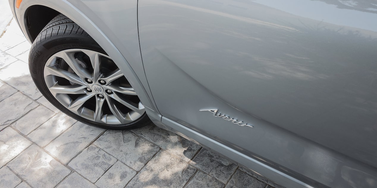 Close-up Driver Side View of a 2025 Buick Encore Avenir Tire and Model Logo